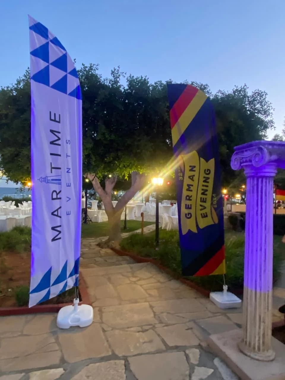 Maritime Events and German Evening flags lit up at dusk at the hotel entrance
