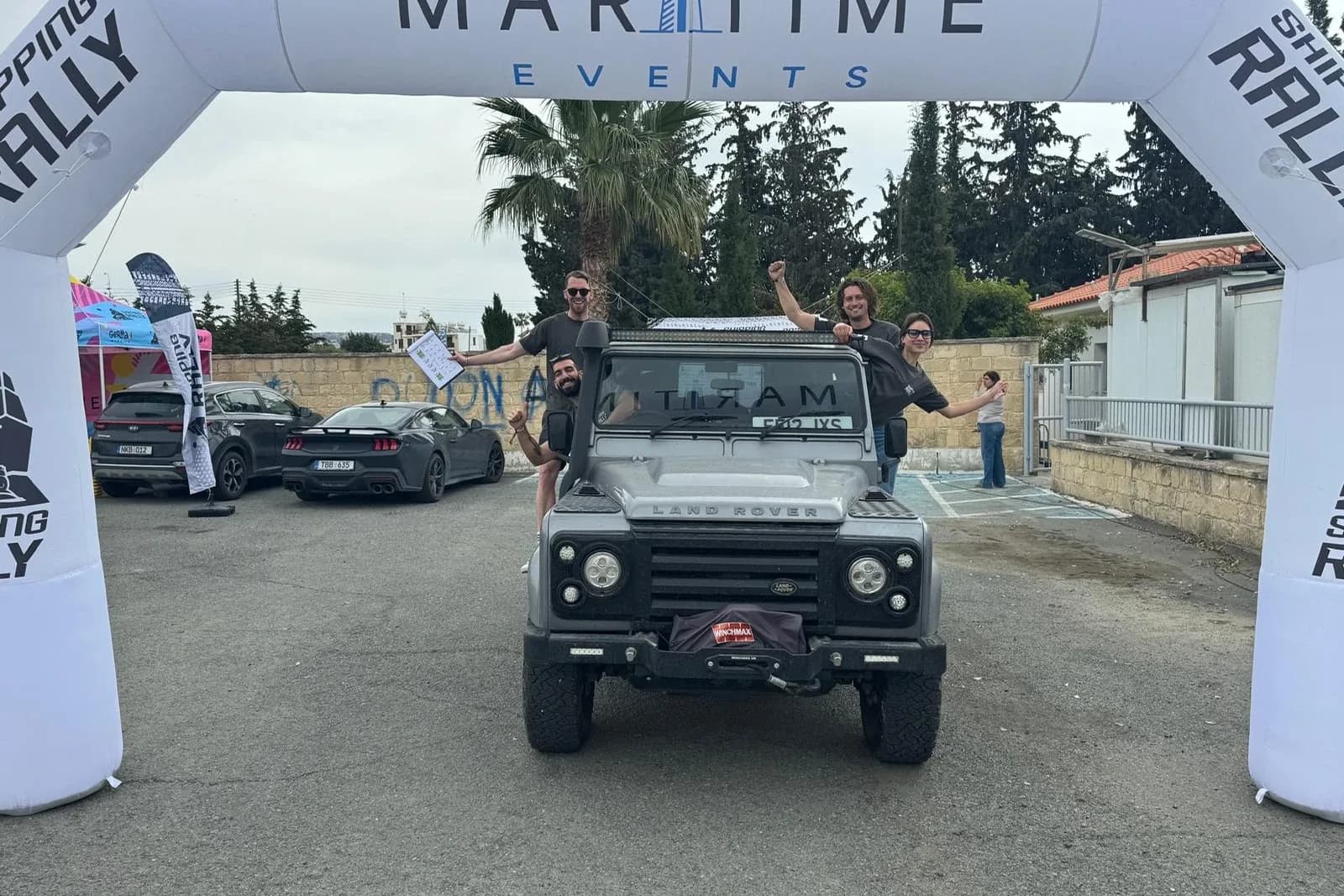 A Land Rover Defender and its team under the Cyprus Shipping Rally start arch